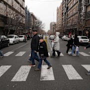 Folk går över gatan i centrala Teheran på torsdagsmorgonen.