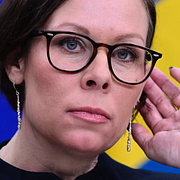 Människor vilar eller bryter ihop utanför flygplatsen i Dubai. Till höger Sveriges utrikesminister Maria Malmer Stenergard.