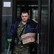 Utredare lämnar lägenhetshuset där Aleksejev sköts.