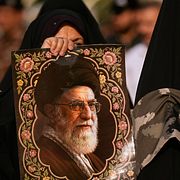 Kvinna håller upp en bild på avlidne högste ledaren Ayatolla Ali Khamenei.