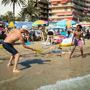Badgäster spelar strandtennis på stranden Playa del Cura i Torrevieja. Arkivbild.