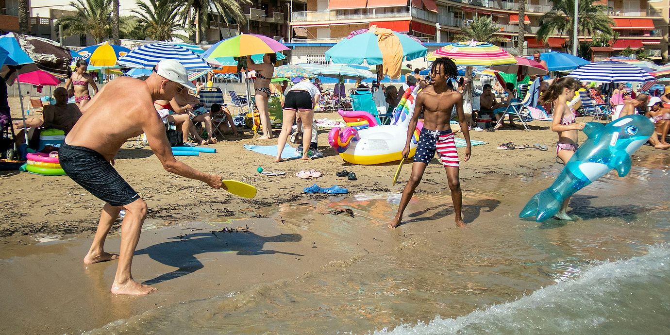 Badgäster spelar strandtennis på stranden Playa del Cura i Torrevieja. Arkivbild.