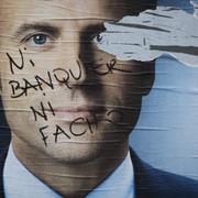 Valkampanjsaffisch med Macron. Någon har klottrat på den med orden: Varken bankir eller fascist. 