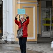 83-åriga Lyudmila Vasilyeva håller upp en skylt under en protest i St Petersburg den 24 februari. ”Folk! Stoppa kriget! Vi är ansvariga för fred på jorden!” står det på skylten.