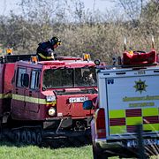 Räddningstjänstens bandvagn bekämpar en gräsbrand.