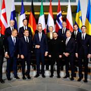 Frankrikes president Emmanuel Macron, Tysklands förbundskansler Friedrich Merz, Ukrainas president Volodymyr Zelenskyj, Steve Witkoff, Jared Kushner och Italiens premiärminister Giorgia Meloni, främre raden från vänster, samt Natos generalsekreterare Mark Rutte, Danmarks statsminister Mette Frederiksen, EU-kommissionens ordförande Ursula von der Leyen, Dick Schoof och Sveriges statsminister Ulf Kristersson. 
