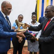 Haitis premiärminister Ariel Henry mottar en gåva från Kenyas utrikesminister Korir SingOei. 