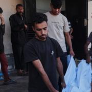 Palestinier bär kroppen efter en död släkting på Al-Aqsasjukhuset i Gaza den 30 september 2025. 
