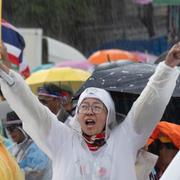 Demonstranter i regn kräver premiärministerns avgång. 
