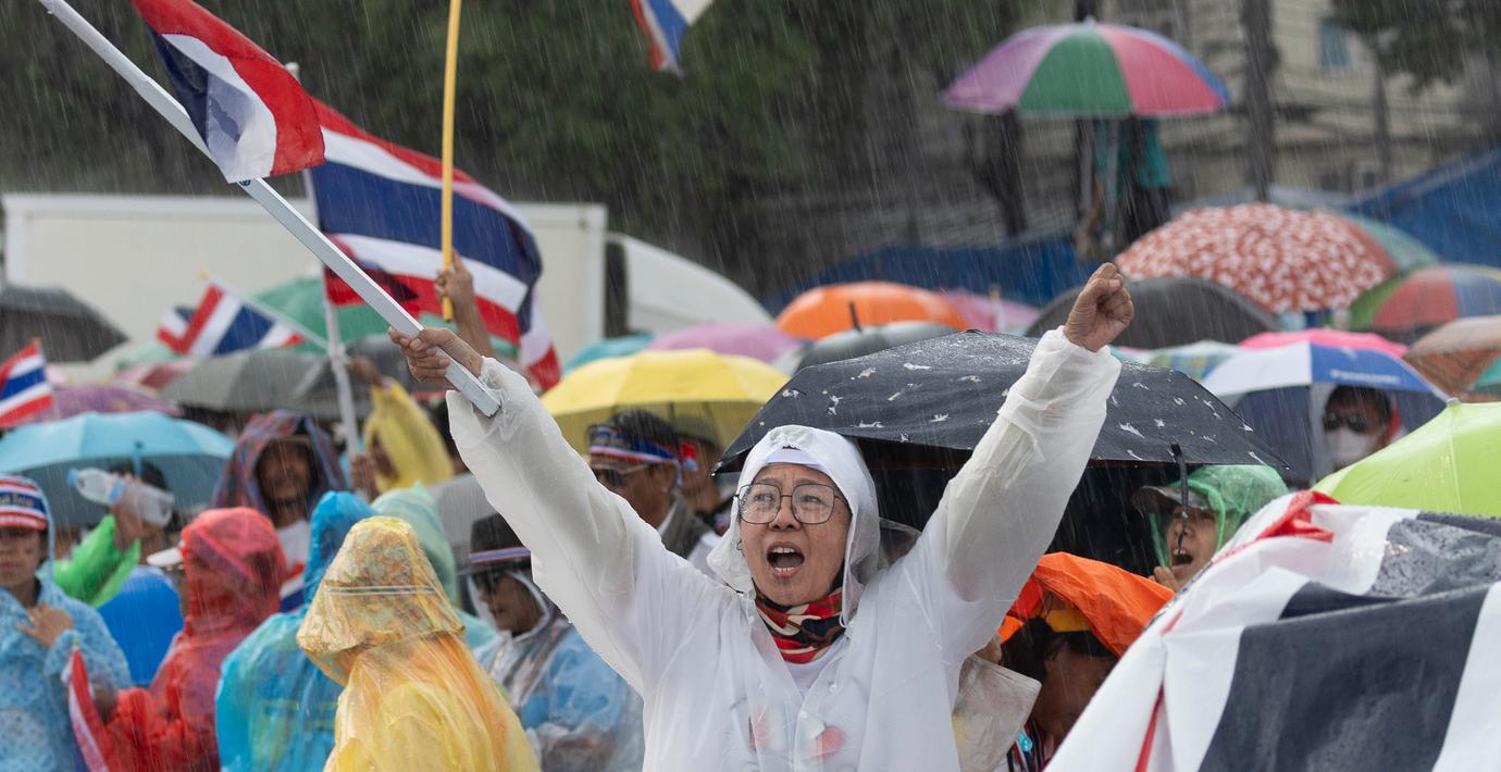 Demonstranter i regn kräver premiärministerns avgång. 
