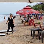 Turister sitter på en strand i Bali, Indonesien.