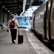 En kvinna med rullväska går på Stockholms centralstation. 