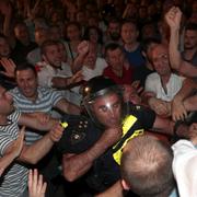 Demonstranter går till attack mot en polisman i Tbilisi i Georgien. 