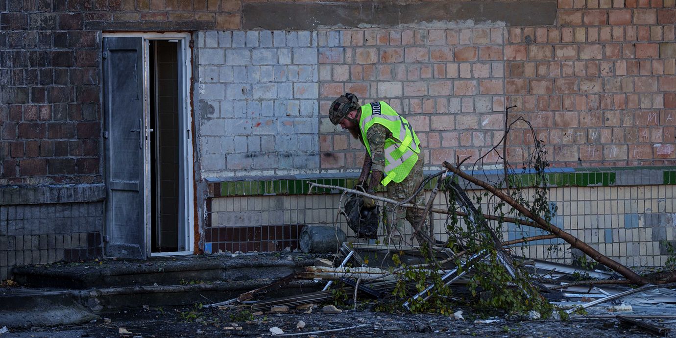 Polis bär bort delar av en drönare som träffat en skola i Kyjiv, 1 oktober 2026.