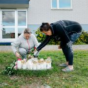 Människor tänder ljus utanför huset där kvinnan överfölls. 