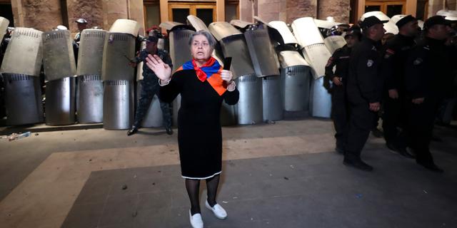 En kvinna bärande en halsduk med armeniska färger framför poliser i Armeniens huvudstad Jerevan. Vahram Baghdasaryan / AP