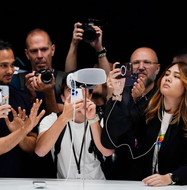 IONA crowd gathers around the Apple Vision Pro headset. Jeff Chiu / AP