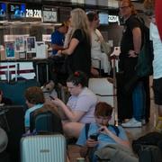 Resenärer väntar vid en incheckningsdisk på Roms internationella flygplats, 15 juli 2023. 