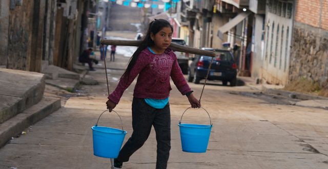 En flicka hämtar vatten i Comachuen, Mexiko 19 januari 2022.  Fernando Llano / AP