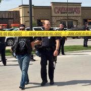 Polis eskorterar en man bort från skottlossningen i Waco.
