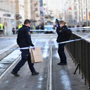  Polisens kriminaltekniker undersöker området efter knivdådet.