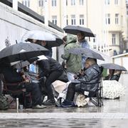 Regnoväder över en grupp köande människor i Stockholm i somras. 