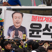 Oppositionsledaren Lee Jae-Myung är en av dem som vill se presidenten ställas inför riksrätt. Till höger: bild på protester mot presidenten. 