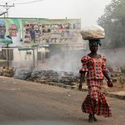 En kvinna går förbi skyltar med presidentkandidaterna i Nigeria. 