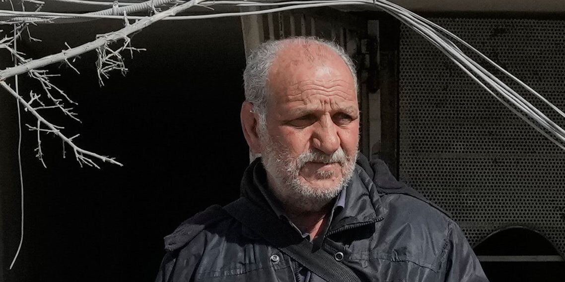 En man ser ut över sin förstörda kontorsbyggnad i Teheran som skadades efter en attack mon en polisstation.