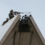 Prickskyttar på Operahuset och flaggning på halv stång på Sydney Harbour Bridge.