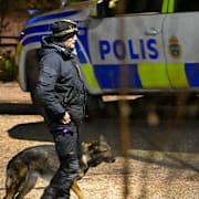 Polisens kriminaltekniker med polishund på plats där en ung man tros ha fått handen avhuggen med machete i början av december. 