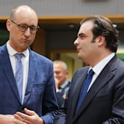 Belgiens finansminister Vincent Van Peteghem (vänster) pratar med sin grekiske motsvarighet Kyriakos Pierrakakis. 