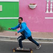 Man åker skateboard i  Bo-Kaap..