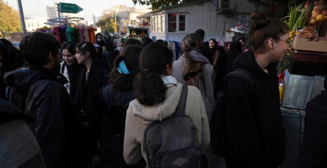 Iranska kvinnor rör sig i ett shoppingdistrikt i Teheran, utan att bära den obligatoriska slöjan. Vahid Salemi / AP