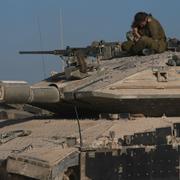 En israelisk soldat sitter på en stridsvagn i närheten av Gaza. 