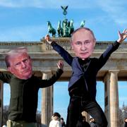 Aktivister bär masker föreställande Donald Trump och Vladimir Putin framför landmärket Brandenburger Tor i Berlin.