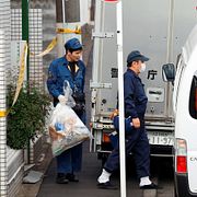 Poliser utanför den lägenhet där flera döda kroppar hittats.
