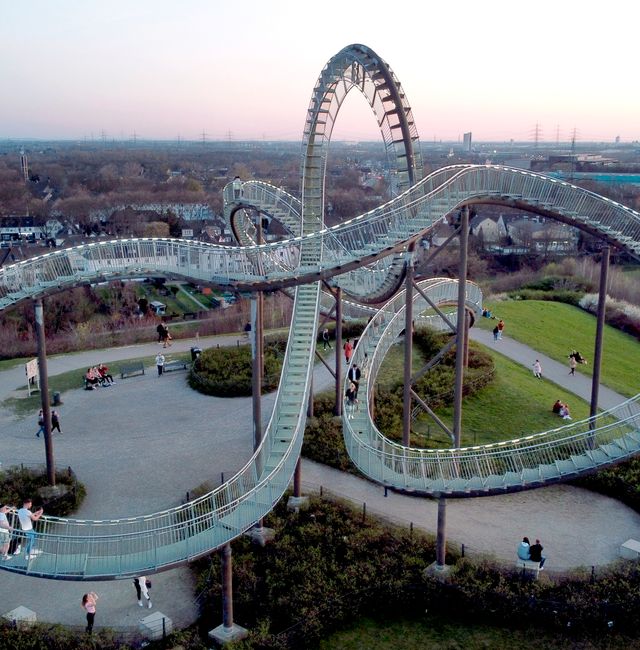 People take pictures of the 'Tiger and Turtle - Magic Mountain' roller coaster sculpture, in Duisburg, Germany, Monday, March 29, 2021.  Michael Sohn / AP
