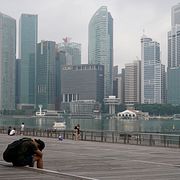 Ensam man med Singapores stadsbild i bakgrunden.