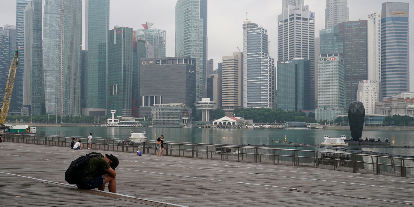 Ensam man med Singapores stadsbild i bakgrunden.