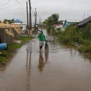 En man på en översvämmad gata i Jamaica. 