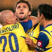 Chievos Denis Godeas omfamnas av Michele Marcolini och Andrea Zanchetta under Uefacupmatch 2006. Arkivbild.