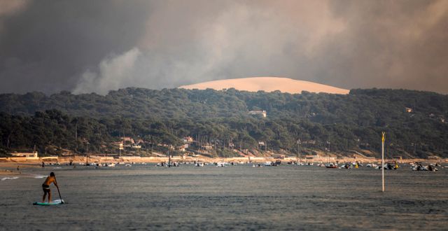 Rök från skogsbränder syns från stranden i Pilat sur Mer, sydvästra Frankrike, 18 juli 2022. Sophie Garcia / AP
