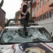 Demonstranter vandaliserar en polisbil under protester i Mexico City på torsdagen.