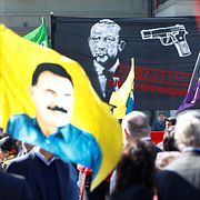 Till vänster en flagga med PKK:s Abdullah Özalan och till vänster en banderoll där pistol riktas mot president Erdogans huvud.