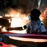 En demonstrant med en amerikansk flagga i Seattle.
