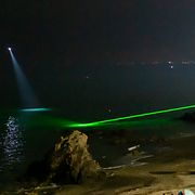 Civilförsvaret använder laserpekare och sökljus för att hålla koll på personer som försöker simma i land.