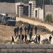 Israeliska soldater och bosättare framför de palestinska hem i Nablus som varit blockerade i fem dagar.