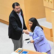 Sverigedemokraternas partiledare Jimmie Åkesson skakar hand med Vänsterpartiets partiledare Nooshi Dadgostar.