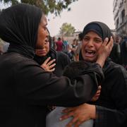 Mamman till Mohammed Al-Sukni, i mitten, som dödades när han försökte nå hjälplastbilar, tröstas av släktingar utanför Shifa-sjukhuset före hans begravning i Gaza City.